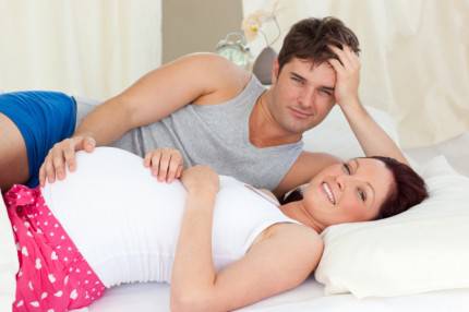 Donna incinta e compagno a letto
