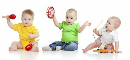 tre bambini si divertono a suonare con piccoli strumenti