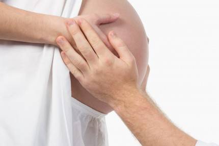 pancia di donna incinta e mani di uomo