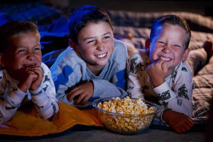 Tre bambini guardano un film divertiti
