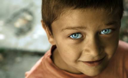 Bambino con viso poco pulito e grandi occhi blu