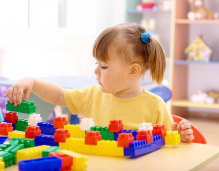 Bambina gioca con mattoncini colorati