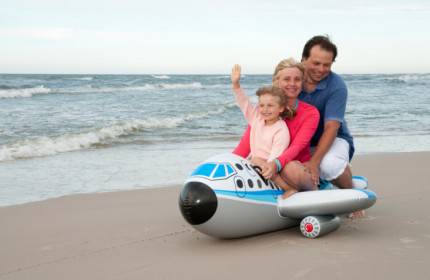 mamma papà e figlia su un aereo gonfiabile  sulla spiaggia