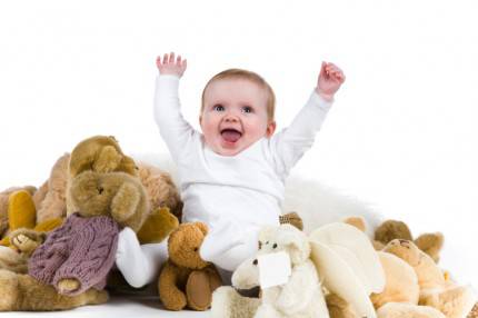 neonato sorride in mezzo a giocatt