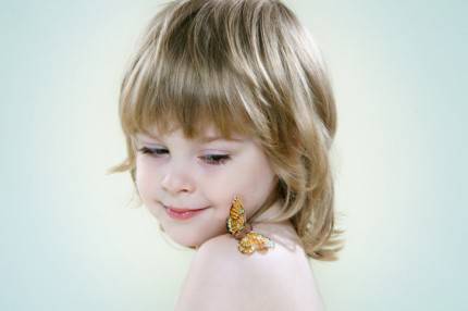 bambina con una farfalla posata sulla spalla