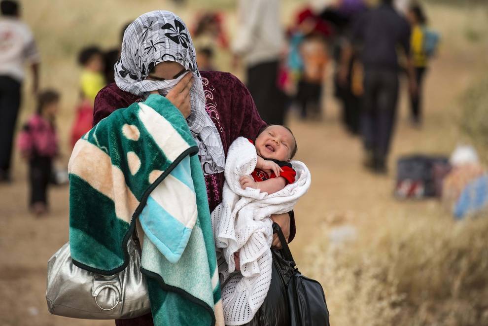 madre con chador e neonato tra le braccia, in situazione di miseria