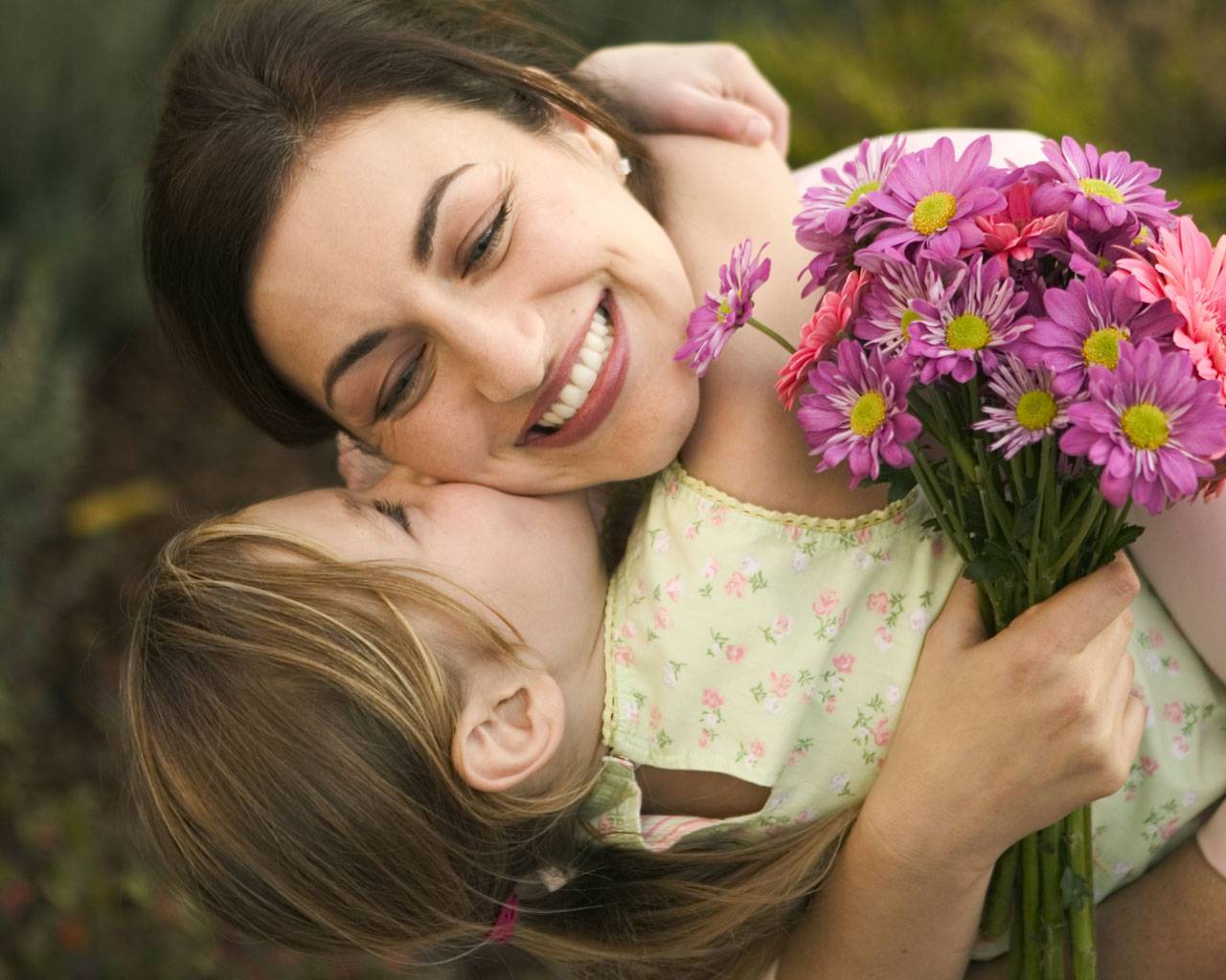 bambina che abbraccia mamma con mazzo di fiori