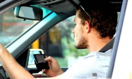 Un uomo scrive un sms mentre guida