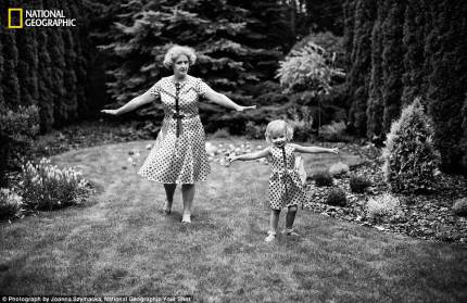nonna e nipote provano passi di danza su di un prato vestite con uguale abito