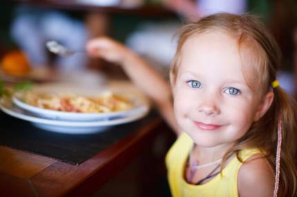 una bambina sta mangiando a tavola