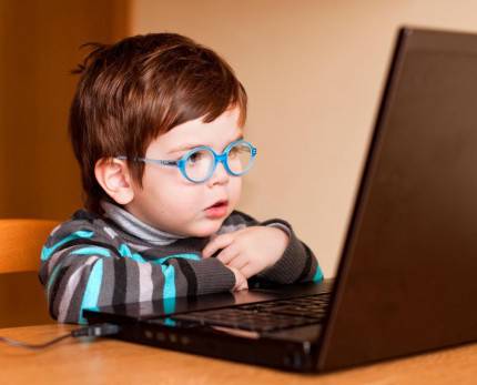 bambino piccolo circa due anni con occhiali davanti lo schermo di un personal computer
