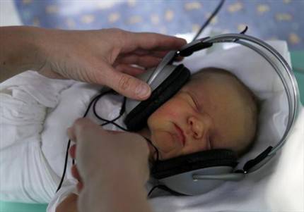 neonato con cuffie sulle orecchie