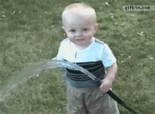 bambino cerca di bere acqua da un idrante da giardino
