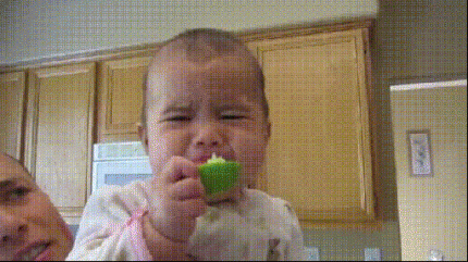 bambina fa una smorfia assaggiando un limone