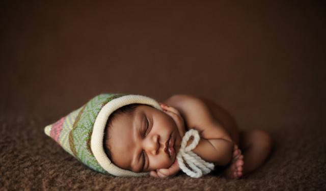 neonato con cappellino verde