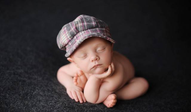 neonato con cappellino buffo