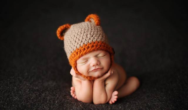 neonato con cappellino arancione