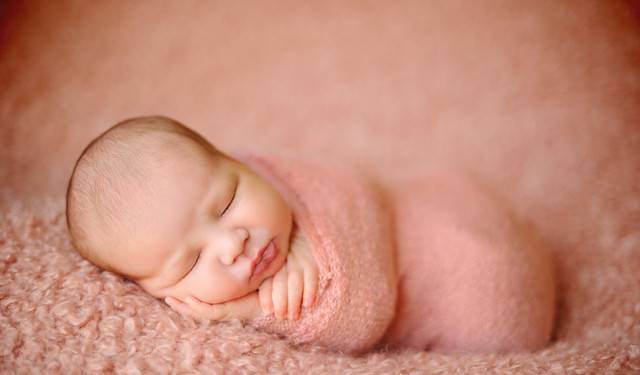 neonato con coperta rosa
