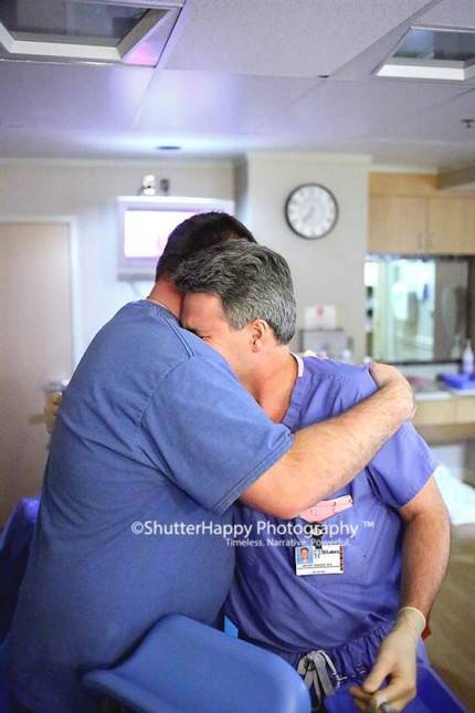 due uomini in camice da ospedale si abbraciano