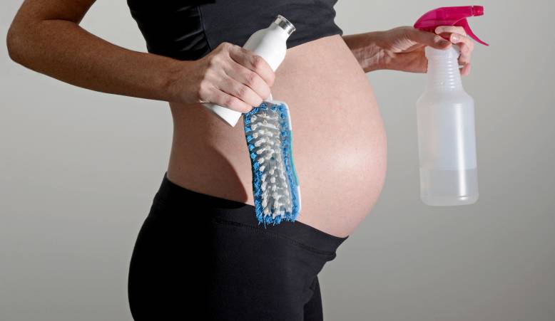donna incinta con prodotti per la pulizia