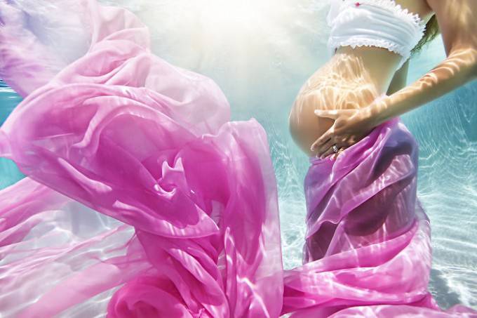donna incinta vestita rosa sott acqua