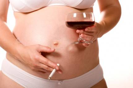 donna incinta con sigaretta e vino
