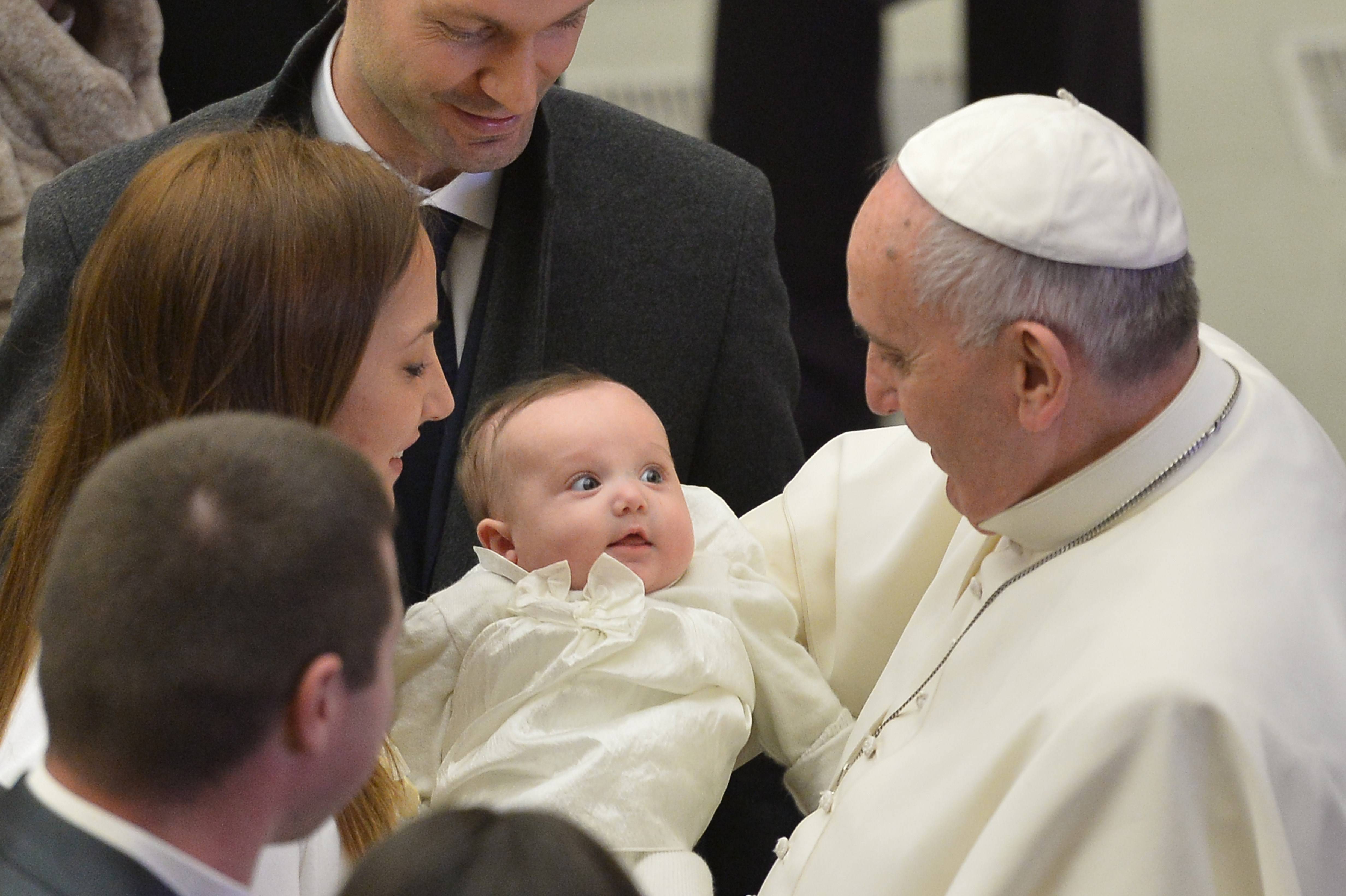 Papa Francesco tiene in braccio un bimbo