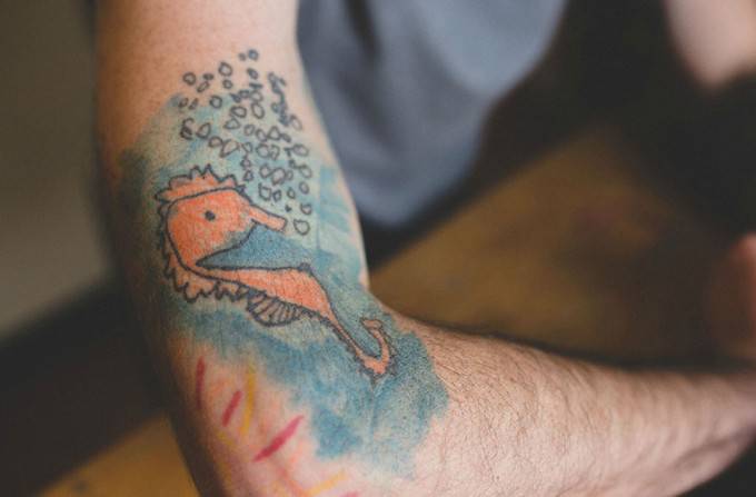 pesce tatuato sul braccio