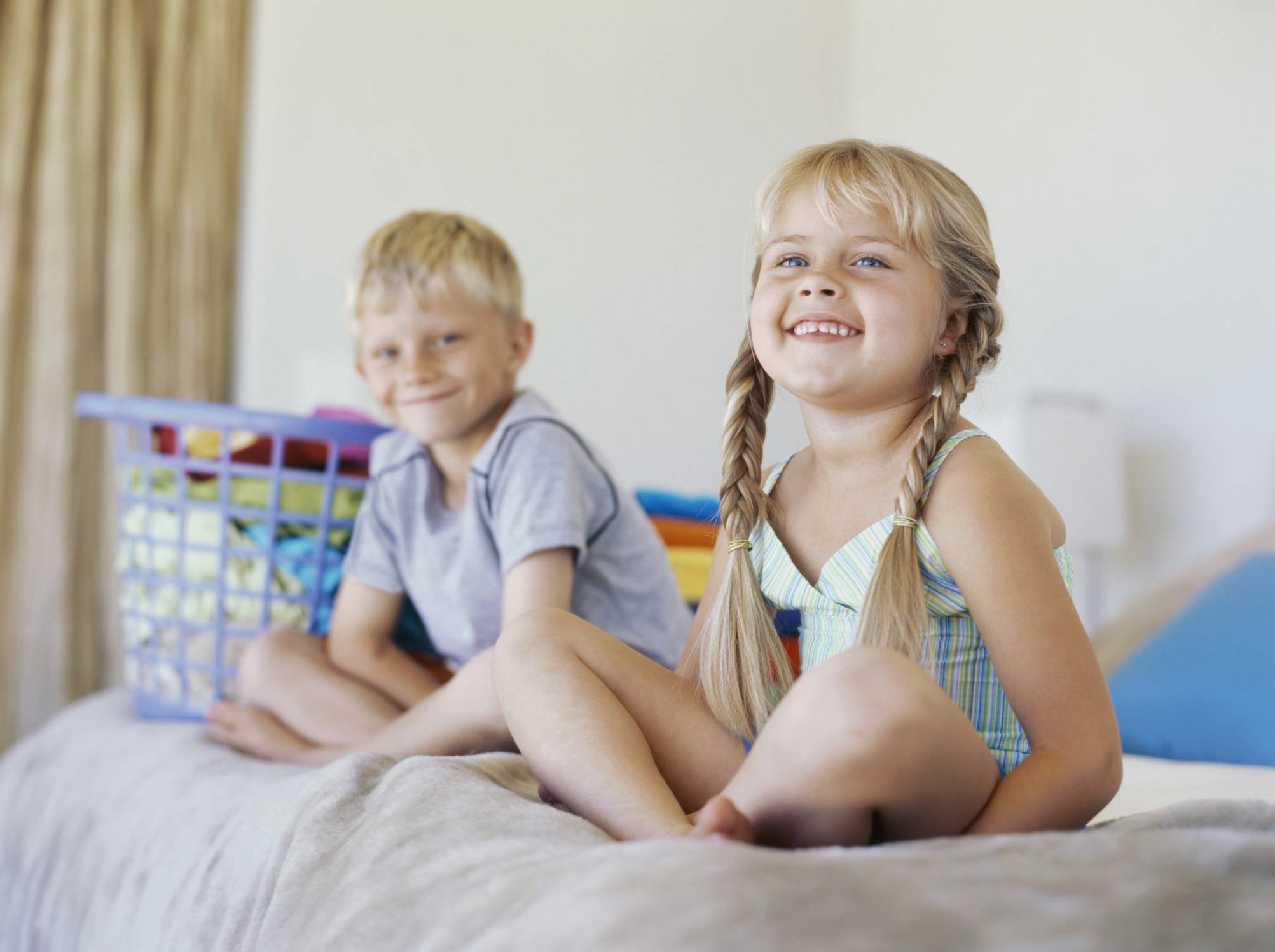 Fratello e sorella seduti sullo stesso letto